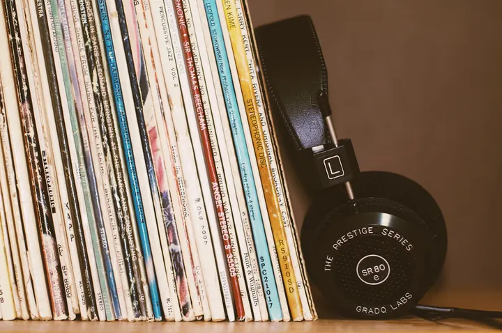 Eine Reihe gebrauchter Schallplatten neben einem Studiokopfhörer